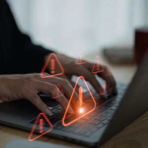 Businesswoman using laptop showing virtual screen icon caution warning triangle and exclamation sign icon Warning of dangerous problems Server error. Virus. Internet network security concept.